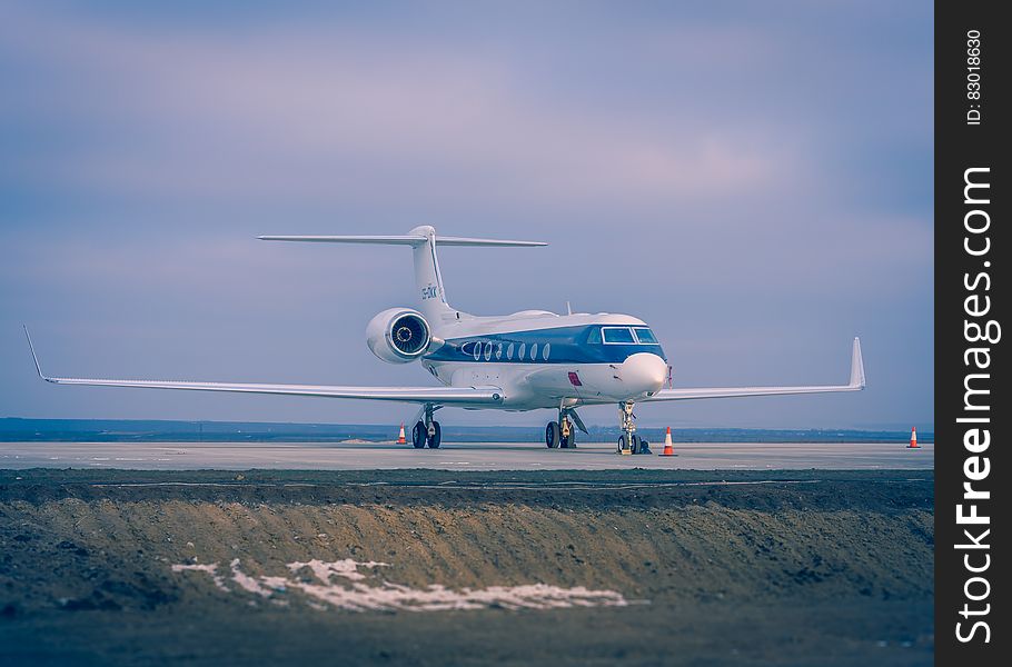 Blue And White Airplane On Concrete Ground