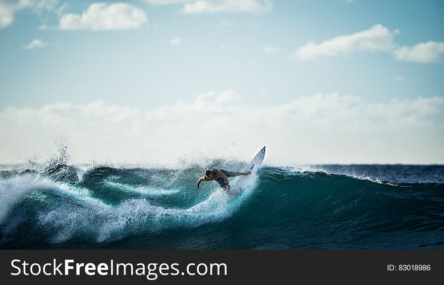 Surfer catching and riding ocean wave on sunny day. Surfer catching and riding ocean wave on sunny day.