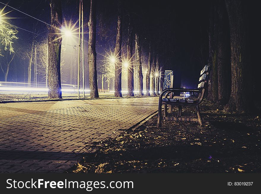 Empty bench on walk at night