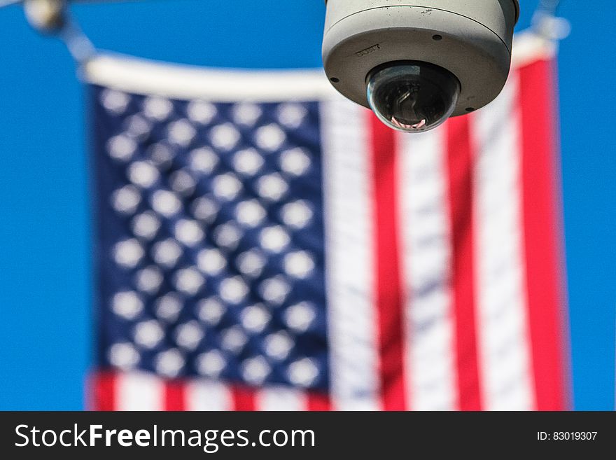 Close up of surveillance camera in front of American flag. Close up of surveillance camera in front of American flag.