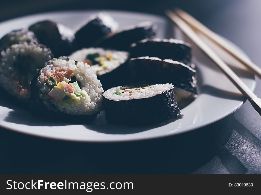 Close up of plate of sushi rolls with chopsticks. Close up of plate of sushi rolls with chopsticks.