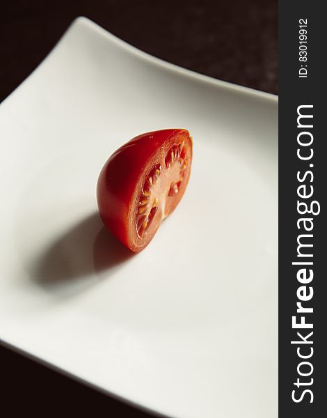 Red Tomato on White Ceramic Plate