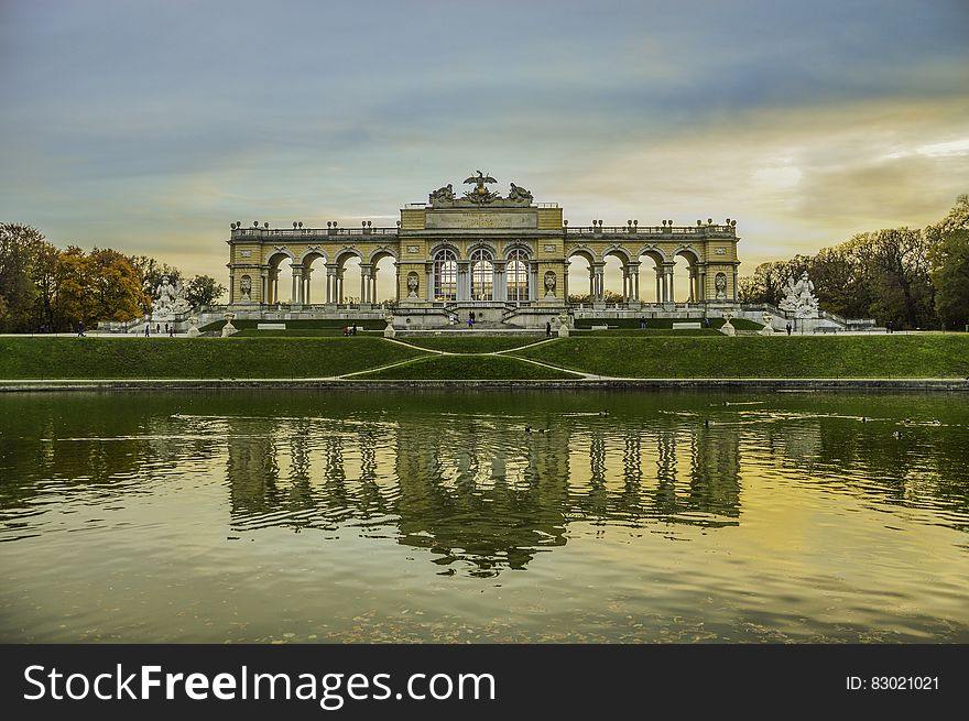 Reflection of gateway in pond at Schonbrunn Palace Gardens, Vienna, Austria at sunset.