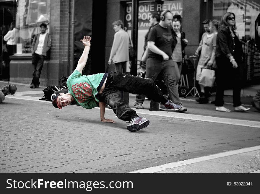 Break dancer performing on city streets with surroundings in black and white. Break dancer performing on city streets with surroundings in black and white.