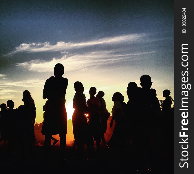 Silhouette of people standing outdoors at sunset. Silhouette of people standing outdoors at sunset.