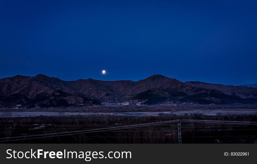 Full Moon Above The Mountain Ranges Near Town