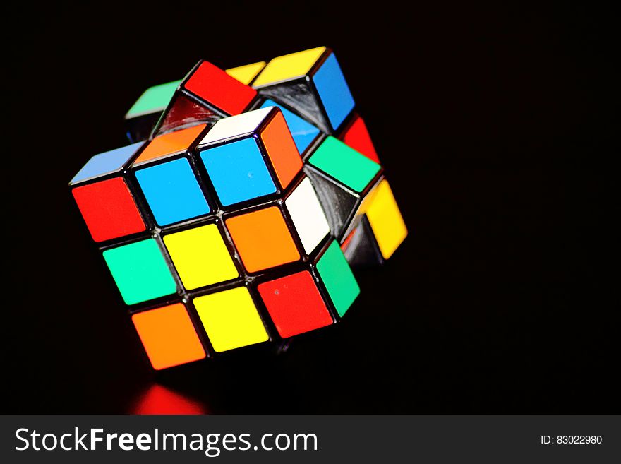 Mixed up Rubik's cube reflecting on black background with copy space. Mixed up Rubik's cube reflecting on black background with copy space.