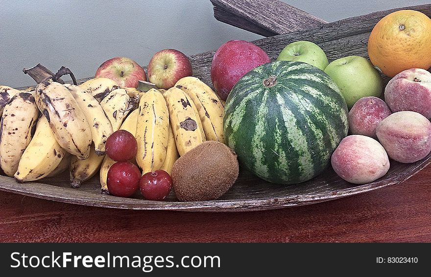 Whole fresh fruit on wooden platter.