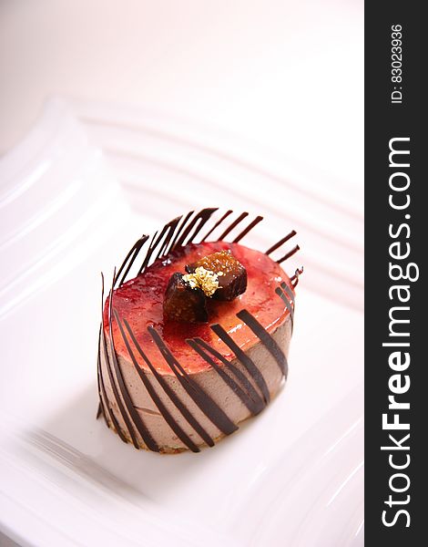 Red and Brown Oval Shape Chocolate Pastry on Ceramic Plate