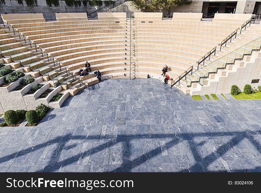 People sitting in large outdoor amphitheater on sunny day. People sitting in large outdoor amphitheater on sunny day.