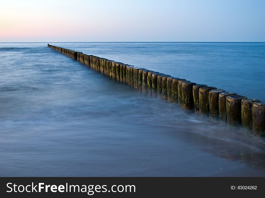 Wooden posts in marina in Baltic Sea on sunny day. Wooden posts in marina in Baltic Sea on sunny day.