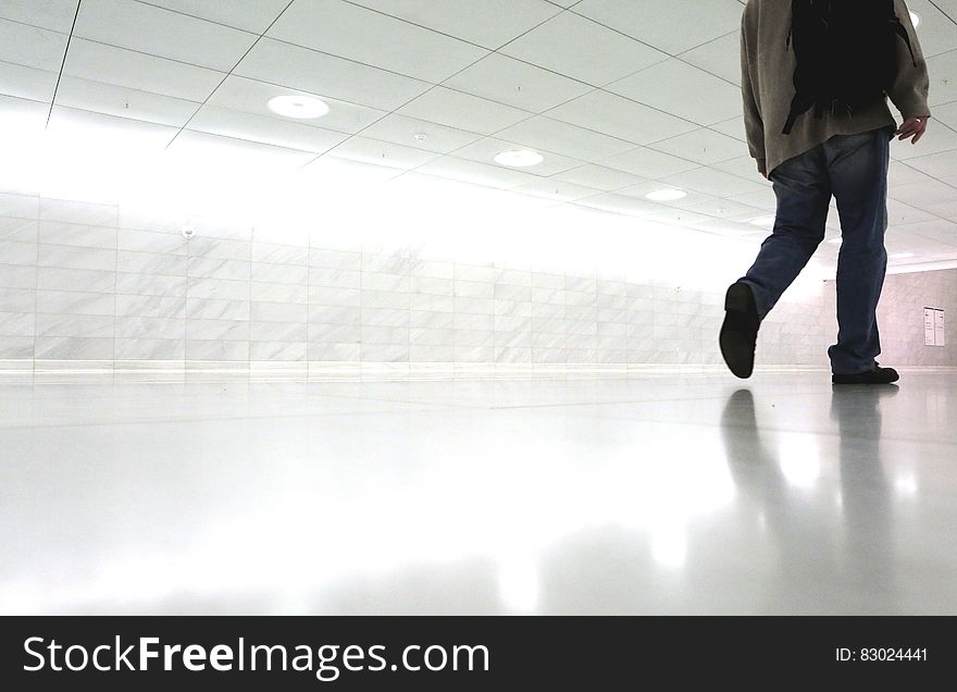 Man walking down white corridor in modern architecture. Man walking down white corridor in modern architecture.