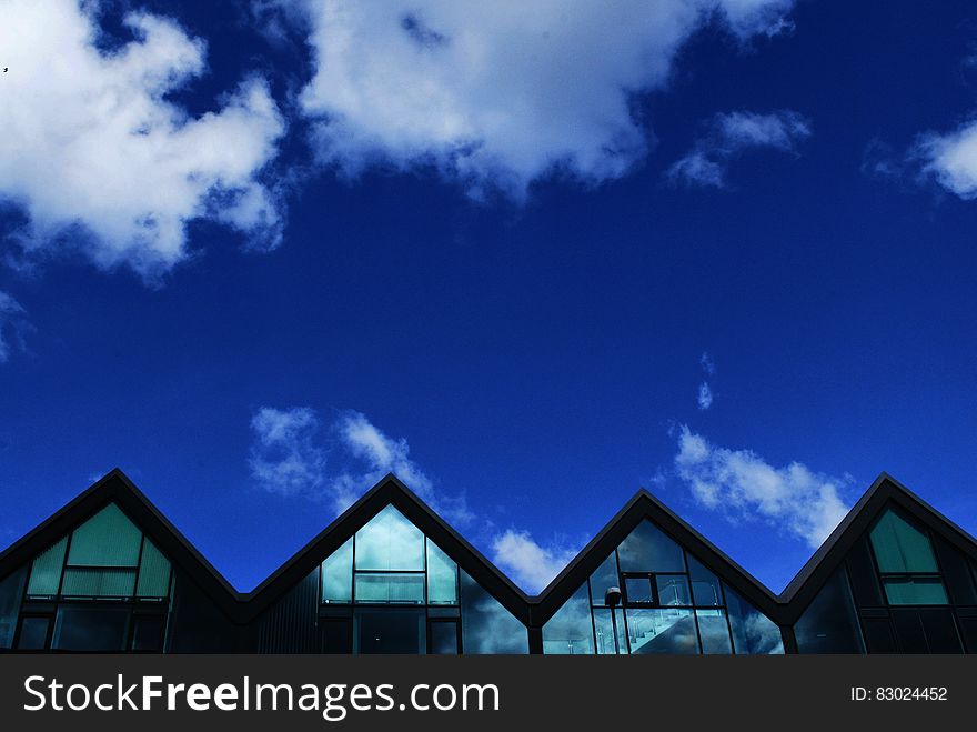 Grey Wood and Glass House Under Blue Sky and Clouds during Daytime