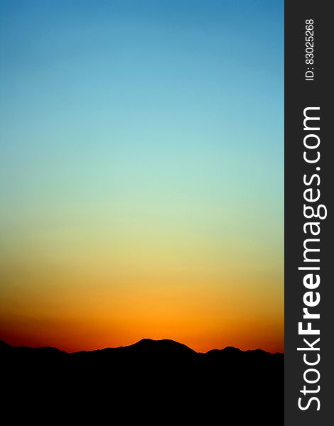 Silhouette of Mountain Under Orange and Blue Sky during Sunset