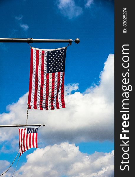 A pair of U.S. flags on horizontal flagpoles. A pair of U.S. flags on horizontal flagpoles.