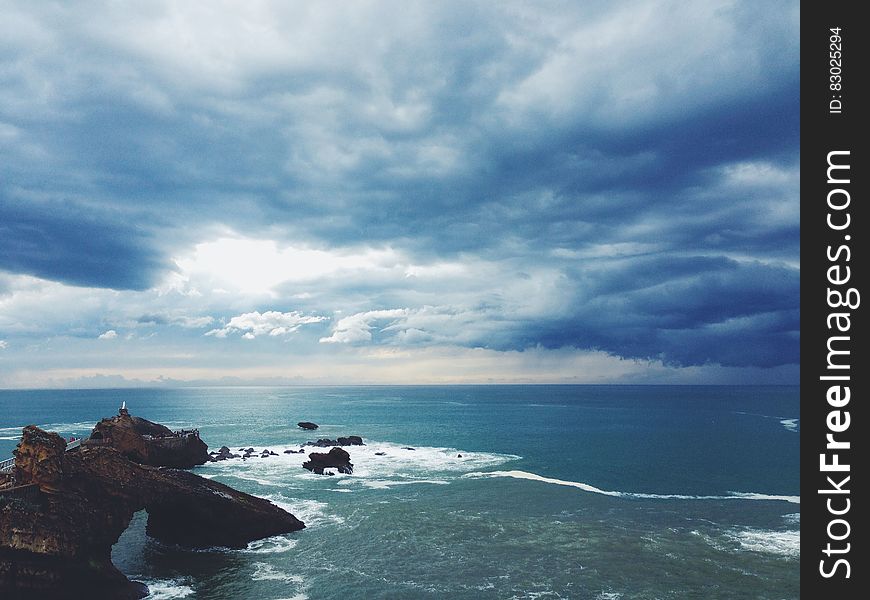 A view over a rocky coast with cloudy skies above. A view over a rocky coast with cloudy skies above.