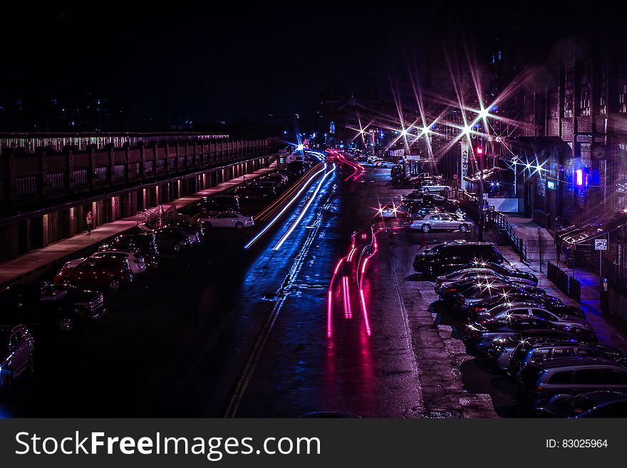 Time Lapse Photo Of Cars Passing Near Parking Lot