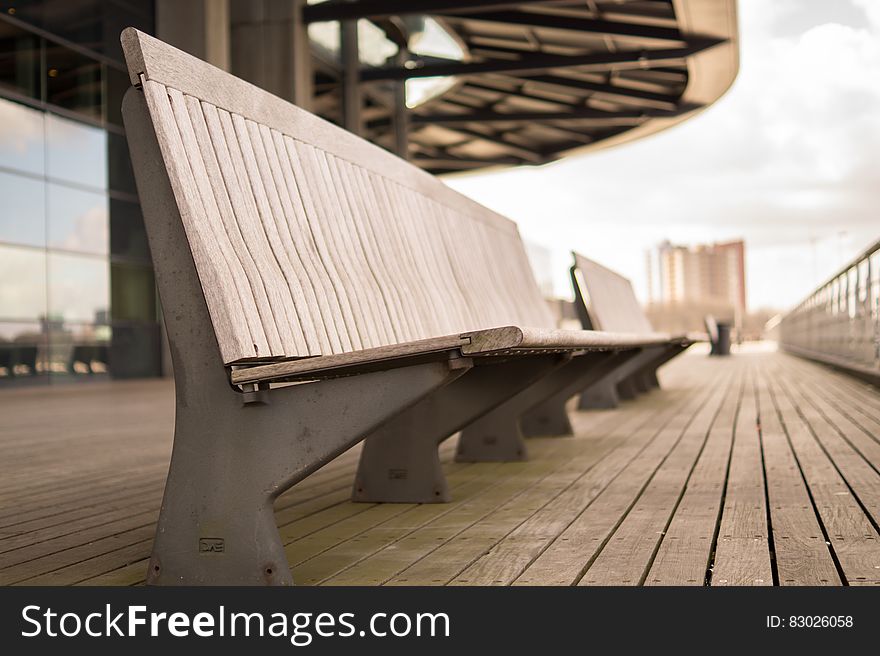 Close up of empty concrete benches on walkway outdoors in city on sunny day. Close up of empty concrete benches on walkway outdoors in city on sunny day.