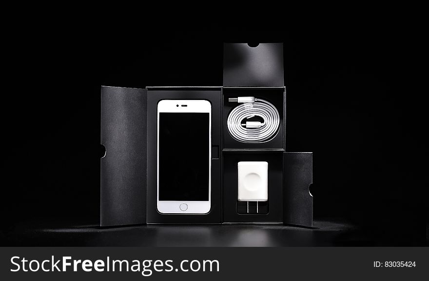 Close up of new smartphone and accessories in block in black and white. Close up of new smartphone and accessories in block in black and white.