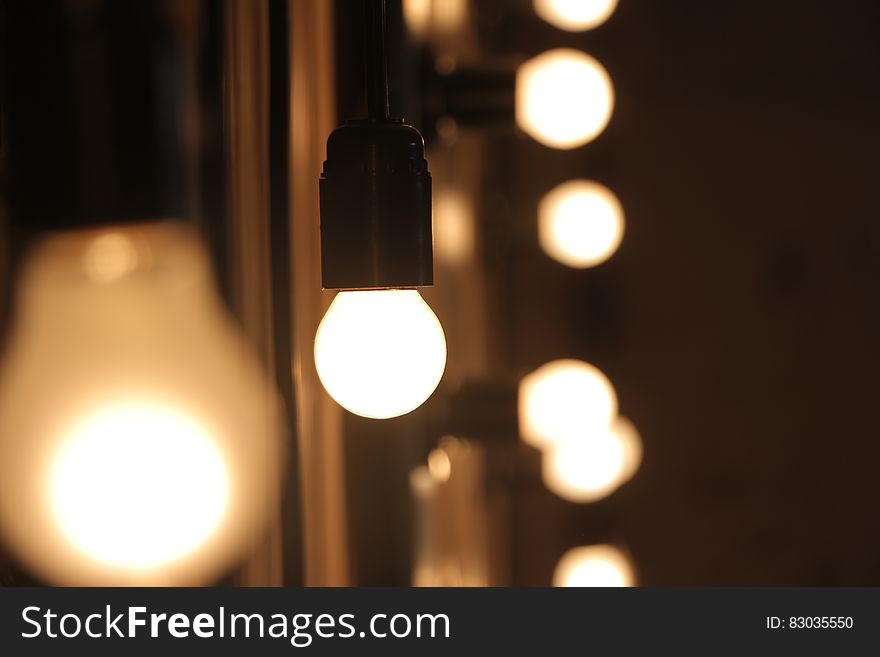 Bokeh blur on glass light bulbs hanging in lighting fixture indoors. Bokeh blur on glass light bulbs hanging in lighting fixture indoors.