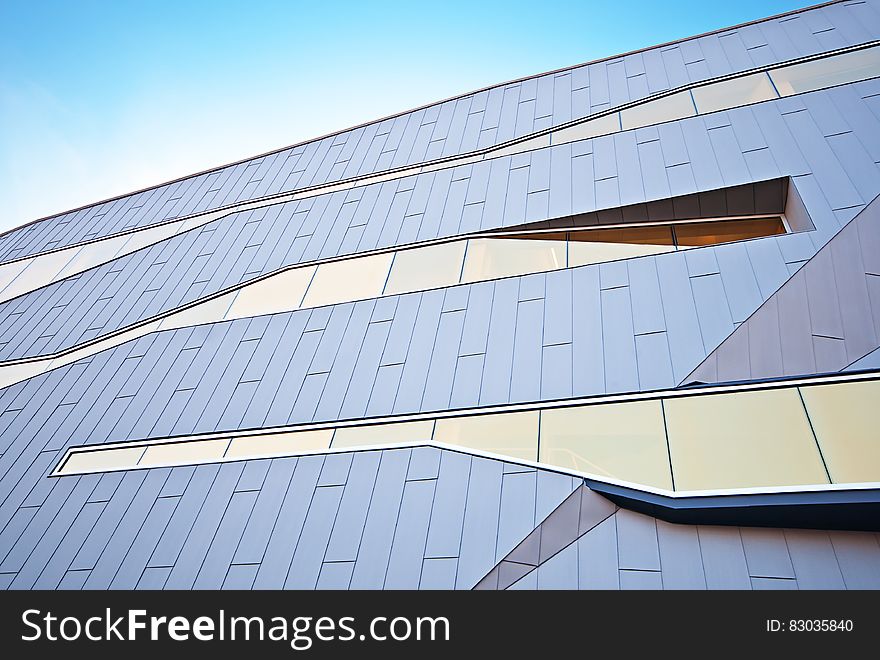 Panels and windows on facade of modern building against sunny days.