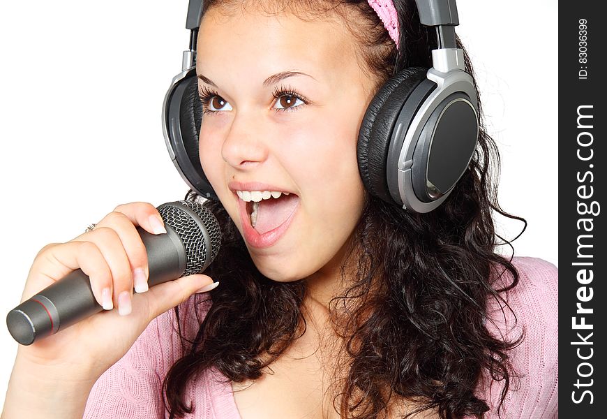 A Girl Holding a Microphone With a Headphone