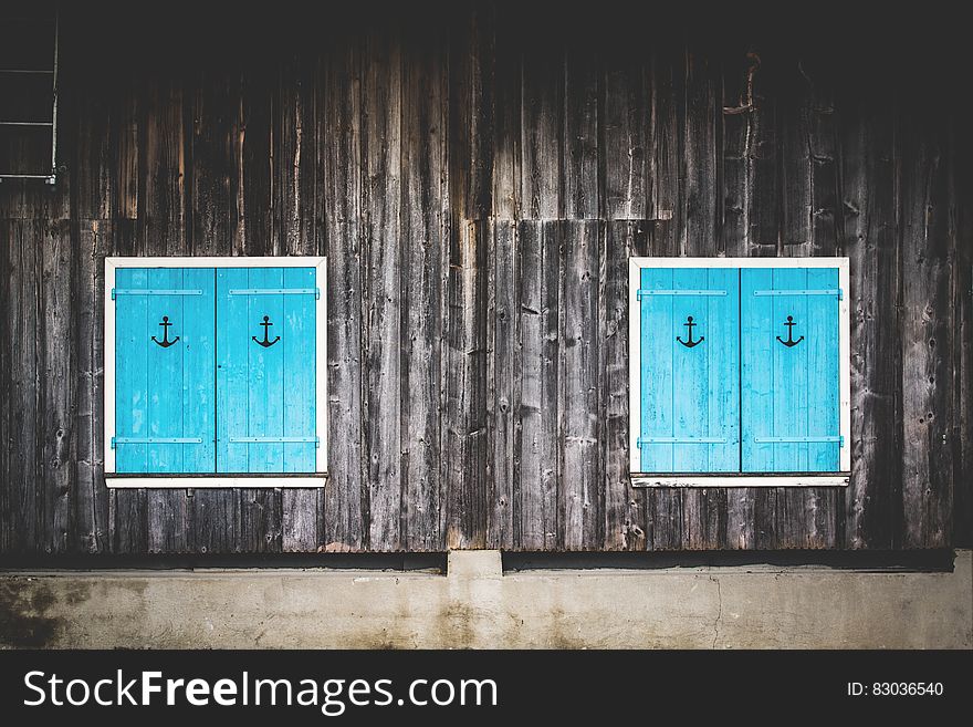 Blue wooden window shutters with anchor signs. Blue wooden window shutters with anchor signs.