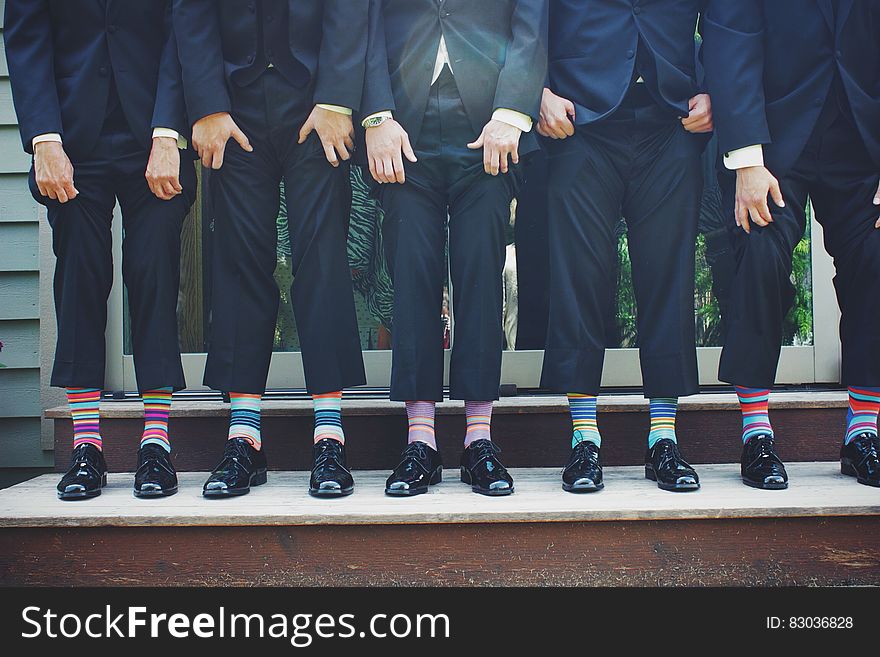 Businessmen standing on steps with colorful striped socks under suits. Businessmen standing on steps with colorful striped socks under suits.