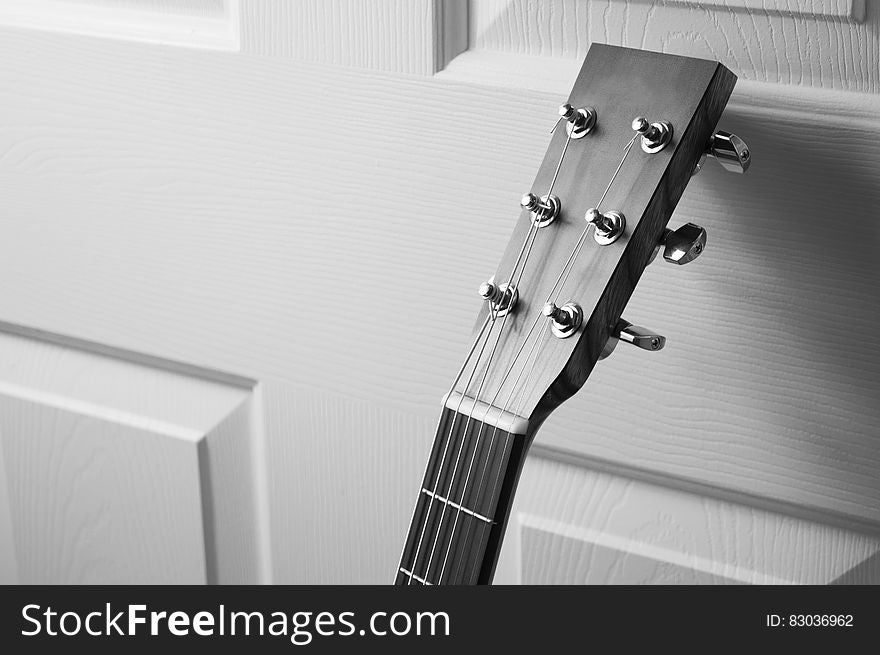 A guitar headstock and bridge close up.