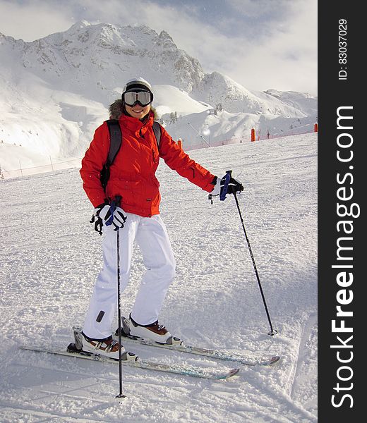 Woman in Red Jacket and White Pants on White Snow