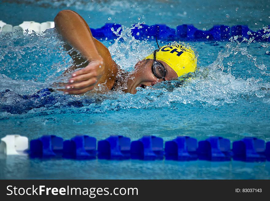 Person Wearing Yellow Swimming Cap on Swimming Pool