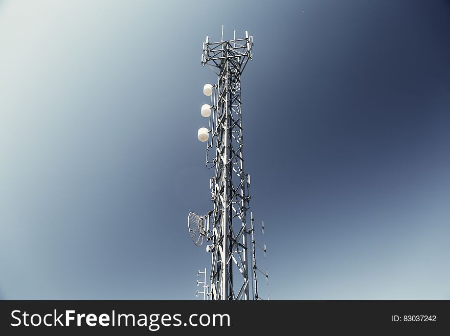 Television transmission tower with blue and white sky background.