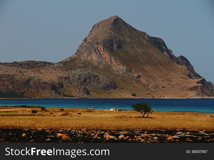 Grey and Brown Rock Formation Near Calm Water Photo