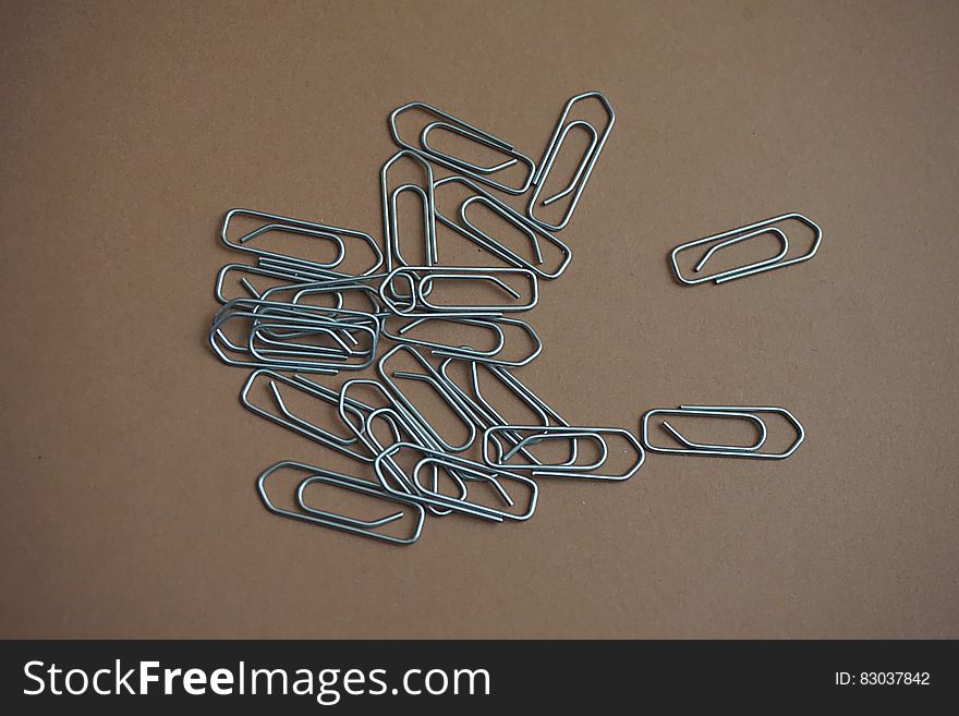 Gray Paper Clip on Brown Table