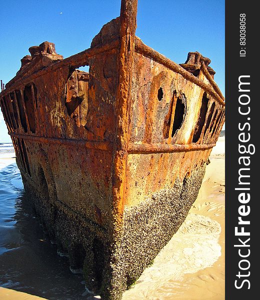 Brown Metal Shipwreck on Seashore during Daytime