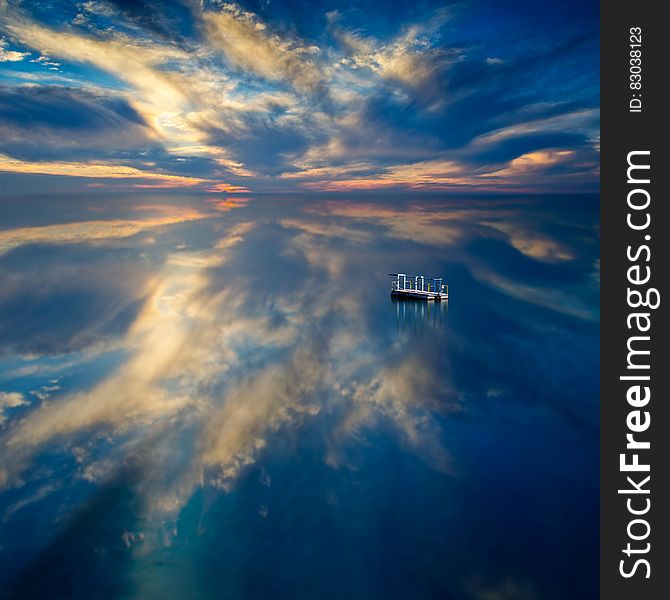 Blue waters with raft reflecting clouds and colors at sunset. Blue waters with raft reflecting clouds and colors at sunset.