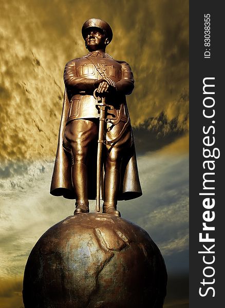 Man in Coat Statue on Globe