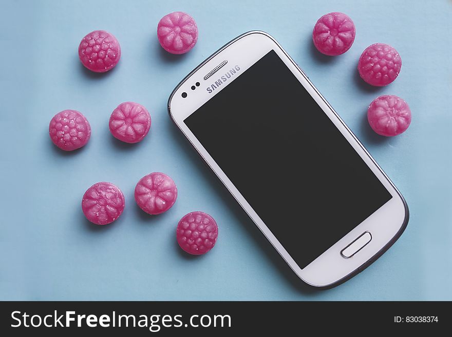 Pink candies and white smartphone