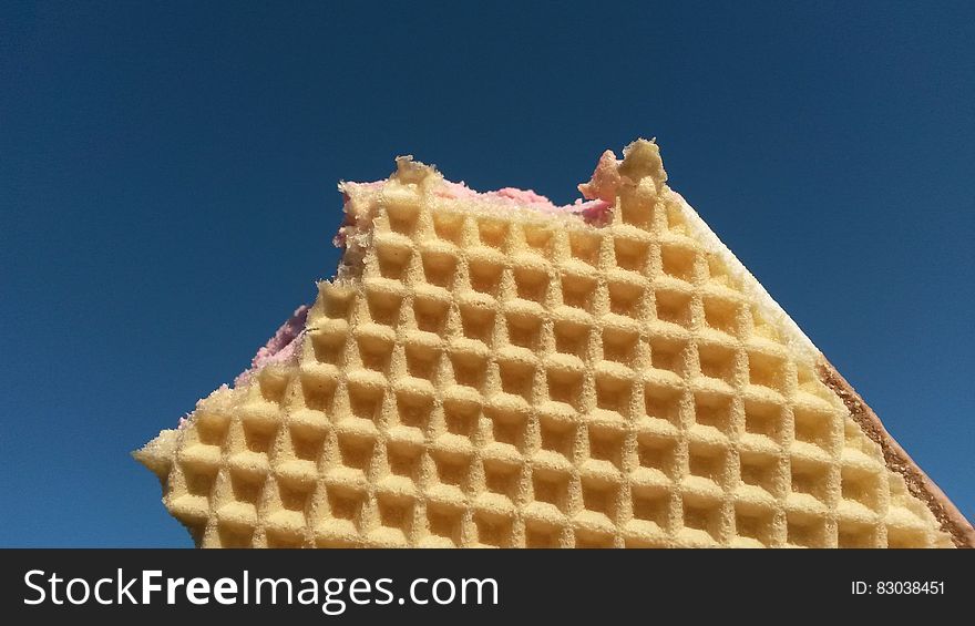 An ice cream sandwich with waffles against the blue skies.