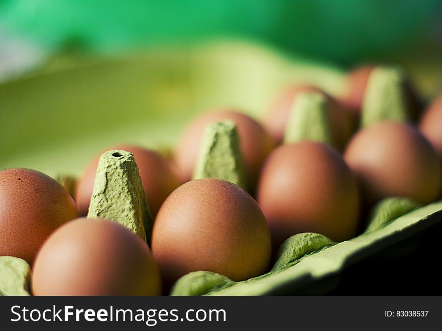 Close up of brown eggs in green carton. Close up of brown eggs in green carton.