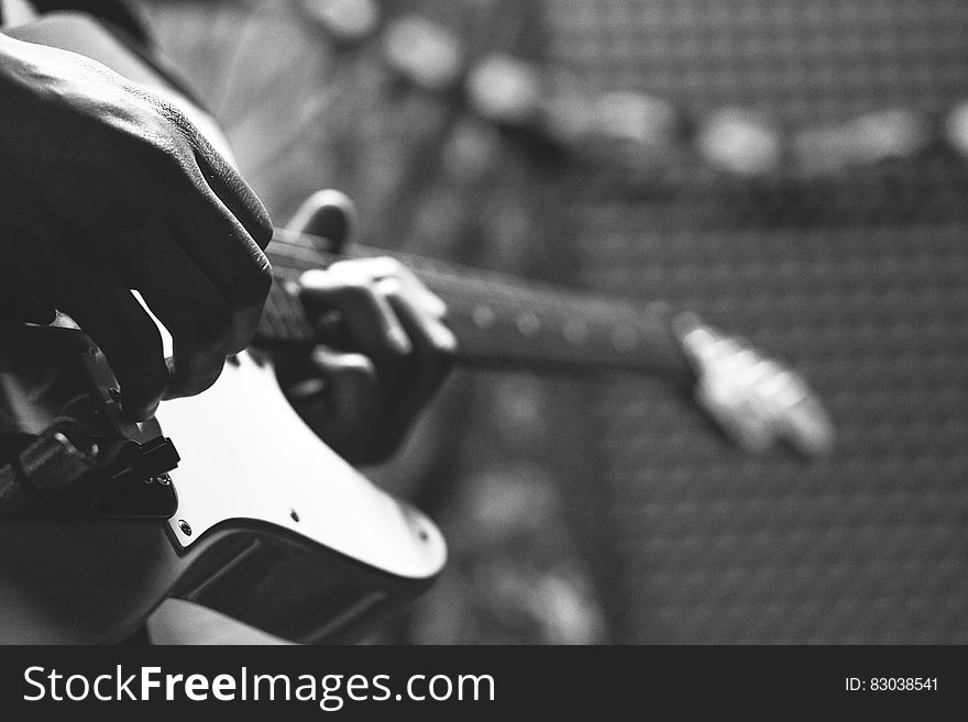 Grayscale Photo of Person Holding Electric Guitar