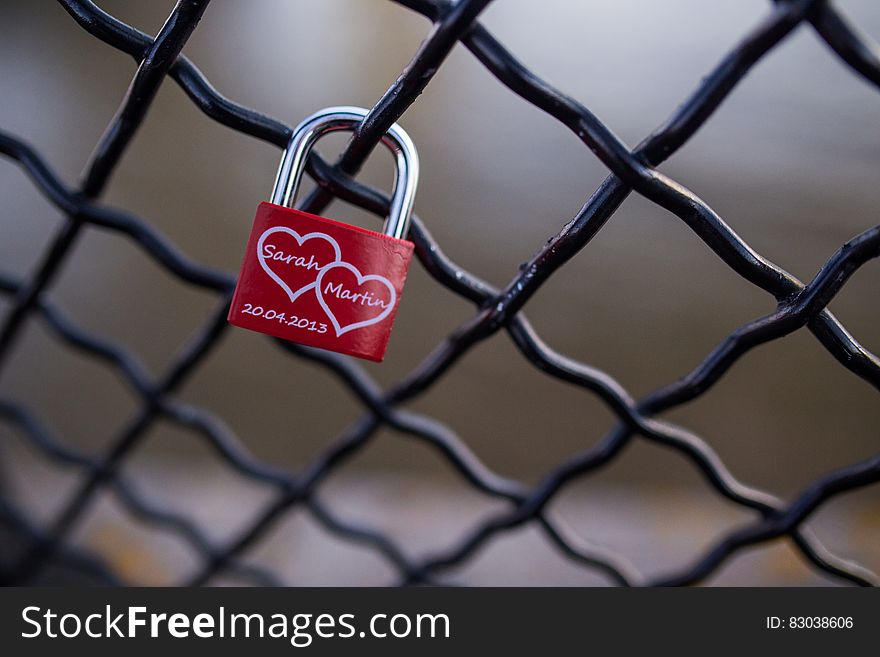 Red and Stainless Steel 2 Hearts Padlock on Black Cyclone Fence during Daytime