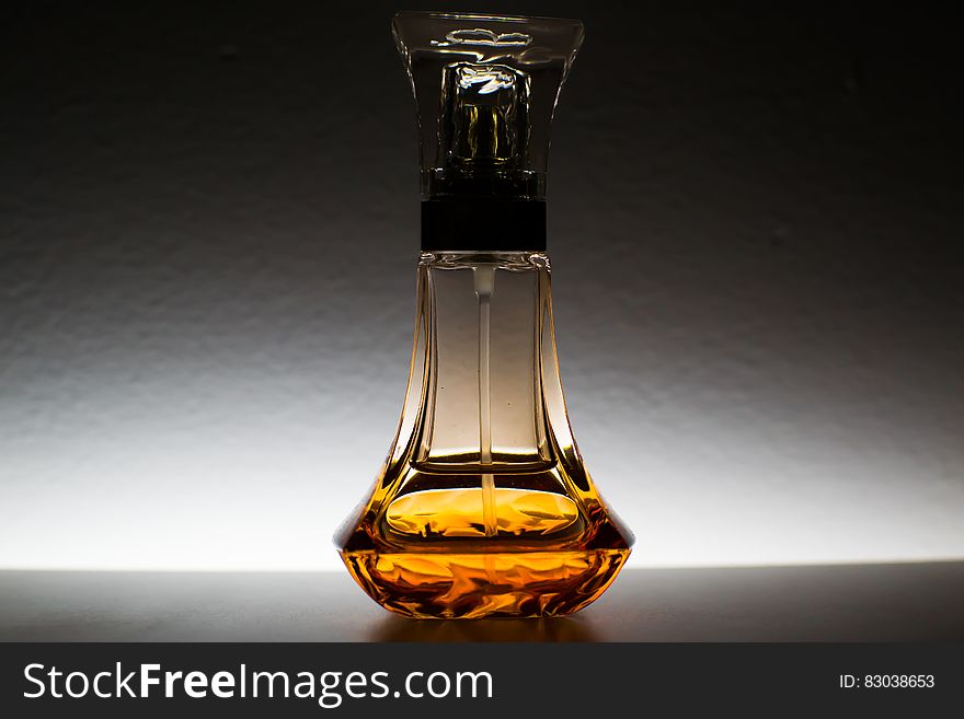 Close up of decorative perfume bottle with amber liquid.