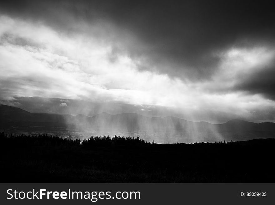 Clouds over forest landscape on hillside in black and white. Clouds over forest landscape on hillside in black and white.