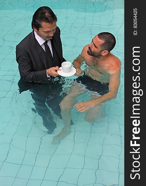 Man In Business Suit With Coffee In Swimming Pool