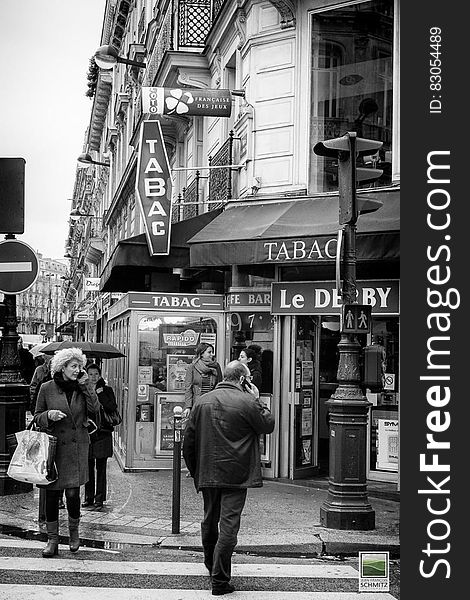 Pedestrians on French street outside shops in black and white. Pedestrians on French street outside shops in black and white.