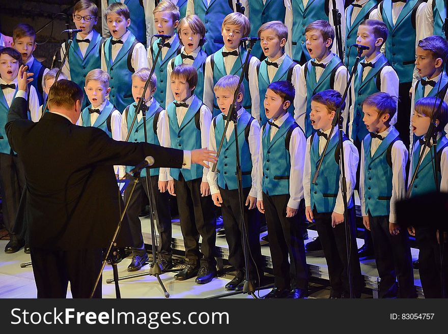 Boys choir performing onstage with conductor. Boys choir performing onstage with conductor.