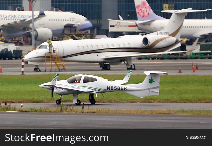 Commercial, corporate and small aircraft on busy international airport runway. Commercial, corporate and small aircraft on busy international airport runway.