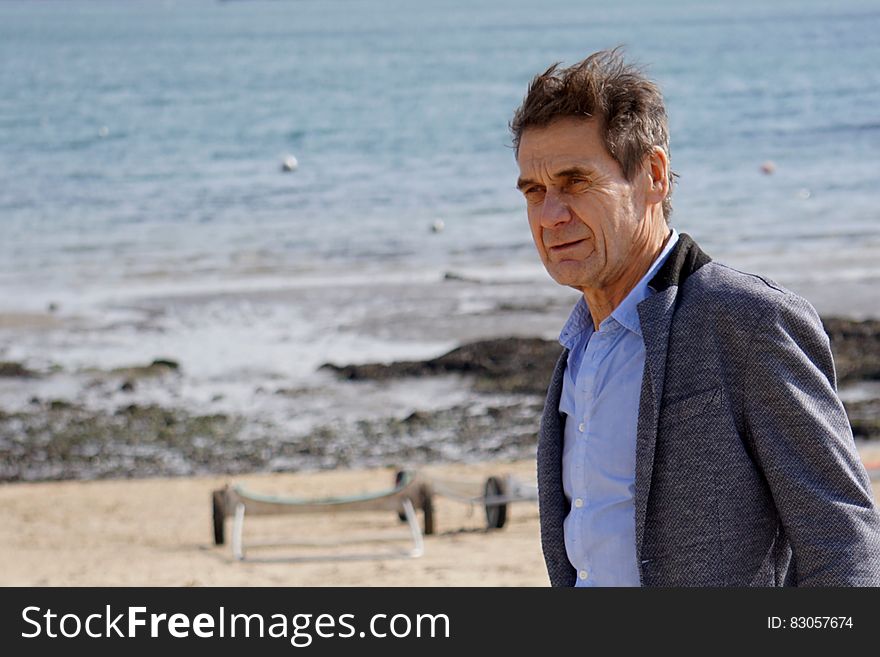 Mature man in business jacket on sandy beach. Mature man in business jacket on sandy beach.