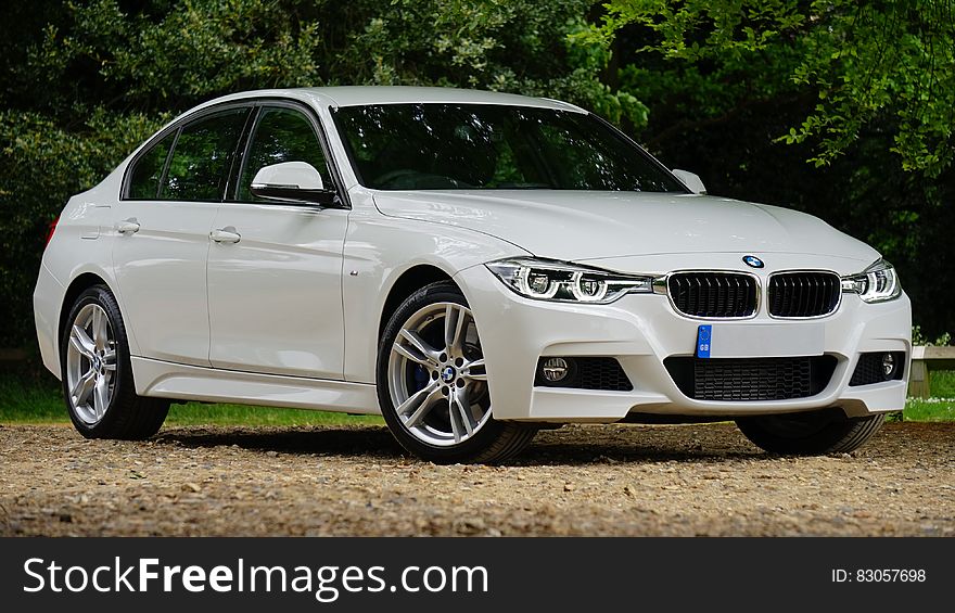 Exterior of white luxury BMW car on dirt road on sunny day. Exterior of white luxury BMW car on dirt road on sunny day.